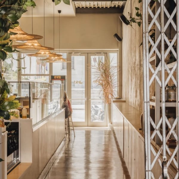 Interior of Jrk! restaurant with light wood accents, woven pendant lights, and a long counter.
